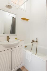 a white bathroom with a sink and a mirror at Odesa city center in Odesa