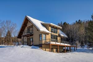 a log home with snow on the ground at Walk to Village! Stunning timber chalet! Hot-Tub, Bonfire & more! in Ellicottville