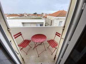 three chairs and a table on a balcony with a view at Résidence De France - 144 - Appartement en plein cœur du Vieux Soulac MAE-4161 in Soulac-sur-Mer