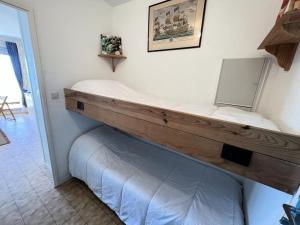 Bett in einem Zimmer mit einer hölzernen Plattform in der Unterkunft Résidence Cap Atlantic - 024 - Appartement avec belle terrasse et vue imprenable sur l'Océan MAE-1951 in Soulac-sur-Mer