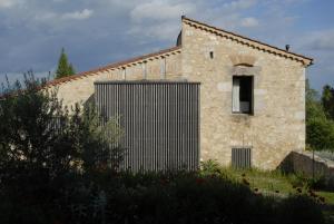 a stone building with a gate in front of it at Temps de Pause - CAMPAGNE in Lautrec