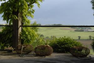 three baskets sitting on a patio with a view of a field at Temps de Pause - CAMPAGNE in Lautrec +2 photos