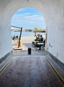 an archway leading to a patio with a view of the water at Acqua e Sale Doddo House in Cetara +5 photos