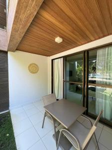eine Terrasse mit Tisch und Stühlen auf einem Balkon in der Unterkunft Studio Iloa Vista Piscina 015v in Barra de São Miguel