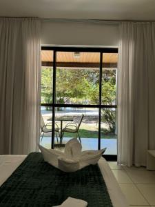 ein Zimmer mit einem Bett mit einem Regenschirm darauf in der Unterkunft Studio Iloa Vista Piscina 015v in Barra de São Miguel