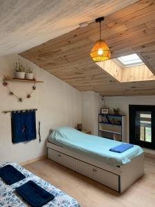 a bedroom with a bed and a pendant light at Les Favouilles - Gîte & Chambres d hôtes in Dauphin
