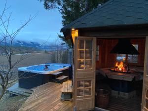 a hot tub on a deck with a fireplace at Ringåsen in Berg