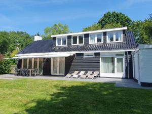 a house with chairs and a table in the yard at De Egel in Oostkapelle