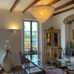 a dining room with a glass table and a chandelier at Villa Acacia in Vallauris