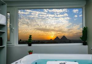 a bath tub in a bathroom with a window with a sunset at La Casa in Cairo