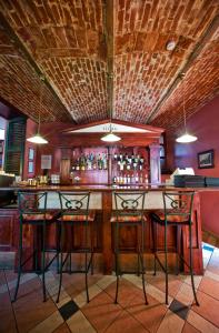 a bar with chairs and a counter with alcohol bottles at Vila Flora in Juodkrantė