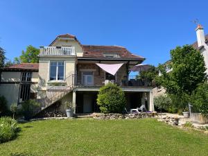 a house with a balcony and a yard at Chambre villa du sentier in Pomponne