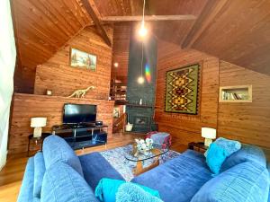 a living room with a blue couch and a tv at Forget Me Not Cottages in Warburton