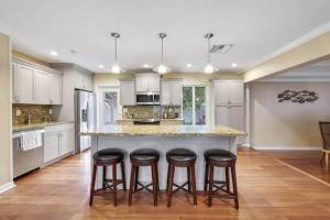 a kitchen with a island with four bar stools at Heated Pool Villa-Walk to Beach-Tiki Bar-Sleeps 8 in Pompano Beach
