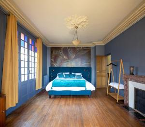 a blue bedroom with a bed and a chandelier at La maison de Florence in Angers