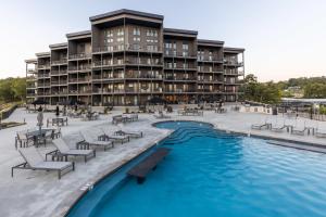 a hotel with a pool and chairs and a building at Whispering Waters Condo in Lake Ozark