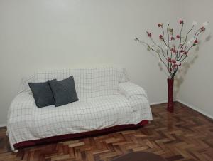 a white couch with two black pillows in a room at Apt térreo Gonçalves Chaves prox Bento in Pelotas