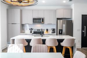 a kitchen with white cabinets and bar stools at Doppio Westside in Orlando