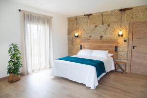 a bedroom with a large bed and a brick wall at La Molinera Casa Rural - Ribeira Sacra in Campo +22 photos