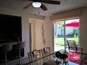 a living room with a glass table and a ceiling fan at Marina Independence - Dpto K-01 in Acapulco