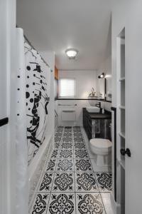 a bathroom with a black and white tile floor at La Maison du Sentier - Foyer et Mt Porphyre in Murdochville