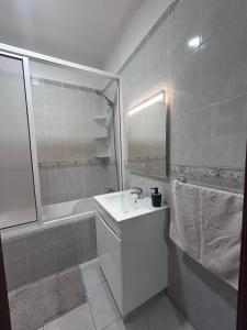 a white bathroom with a sink and a bath tub at Vila Mendes - Ocean View in Arco da Calheta +42 photos
