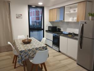 una cucina con tavolo con sedie e frigorifero di Depto centrico a La Plata