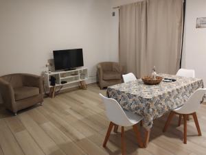 un soggiorno con tavolo, sedie e televisione di Depto centrico a La Plata