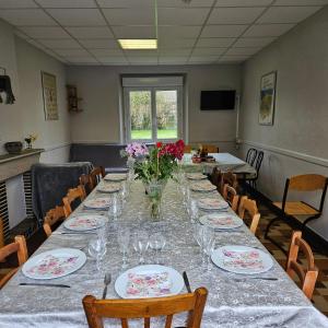 a long dining room with a long table with flowers on it at Gîtes de la terrette in Tribehou +8 photos