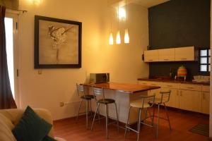 a kitchen with a table and stools in a room at Hotel Casa San Miguel Arcángel in Oaxaca City