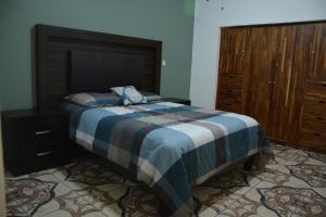 a bedroom with a bed and a wooden dresser at Hotel Casa San Miguel Arcángel in Oaxaca City