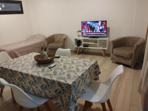 un soggiorno con tavolo, sedie e televisione di Depto centrico a La Plata Altre 2 foto