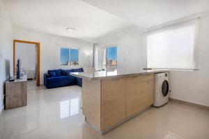 a kitchen and living room with a blue couch at Precioso apartamento en Serena Village in Punta Cana +34 photos