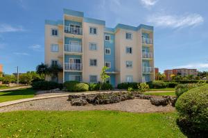 a large apartment building with a garden in front of it at Precioso apartamento en Serena Village in Punta Cana