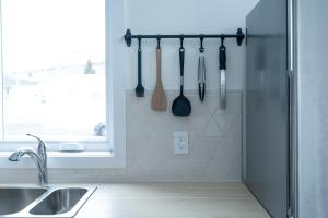 a kitchen with utensils hanging on a wall at La Kobber Hüs - Élégance au coeur de la ville in Murdochville +19 photos
