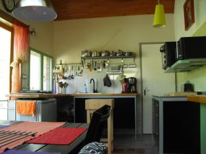 a kitchen with a table and a kitchen with a table and a tableablish at La Maison Imparfaite in Fourbanne