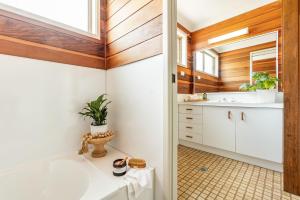 a bathroom with a tub and a sink at Acacia Shores - Waterfront in Yamba +16 photos
