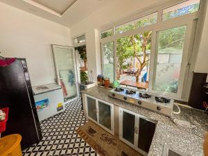 a kitchen with a counter with a stove and a refrigerator at BA DŨNG VILLA COFFEE - ĐẢO PHÚ QUÝ - Bình Thuận in Cu Lao Thu