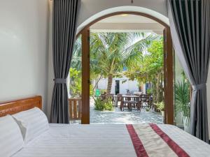 a bedroom with a bed and a view of a patio at BA DŨNG VILLA COFFEE - ĐẢO PHÚ QUÝ - Bình Thuận in Cu Lao Thu