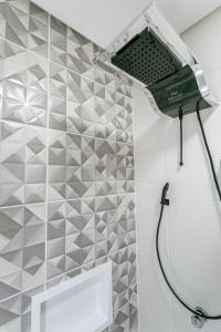 - Baño con ducha y pared de azulejos en Studios Montblanc Campeche, en Florianópolis