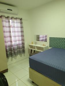 a bedroom with a bed and a desk and a mirror at Ap Morada Nova in Petrolina