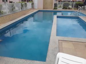 a swimming pool with blue water in a building at Ap Morada Nova in Petrolina +13 photos