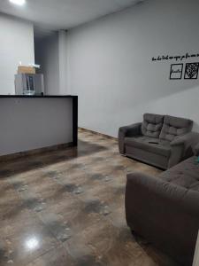 イタニャエンにあるMN Houseのソファ2脚と薄型テレビのあるリビングルーム