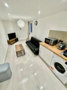 a living room with a couch and a microwave at cozy 1 bedroom flat near cambridge city centre in Milton