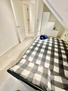 a bedroom with a checkered bed in an attic at cozy 1 bedroom flat near cambridge city centre in Milton