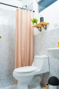 a bathroom with a toilet and a shower curtain at Casa Oriente in San Miguel +18 photos
