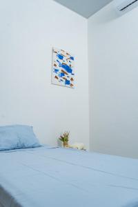 a white bedroom with a bed with a blue pillow at Casa Oriente in San Miguel