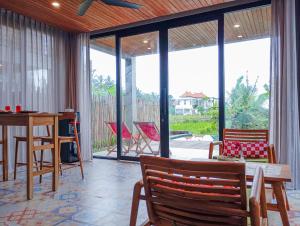 a living room with a table and chairs at Umah Adenium Ubud 2 in Tegalalang