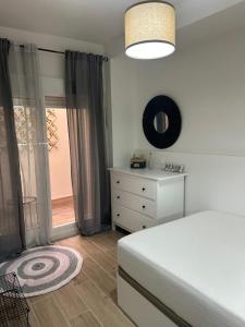 a bedroom with a bed and a dresser and a window at Apartamento Sol y Playa in Rota