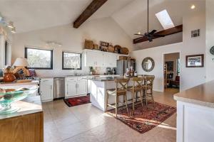 a kitchen with white cabinets and a large island with bar stools at Waterfront Possum Kingdom Lake Family Home in Graford
